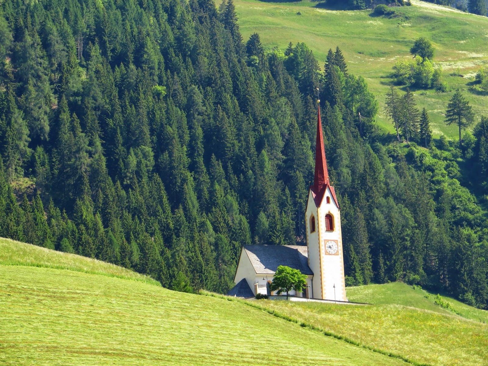 Chiesa tra prati e boschi lungo la valle
